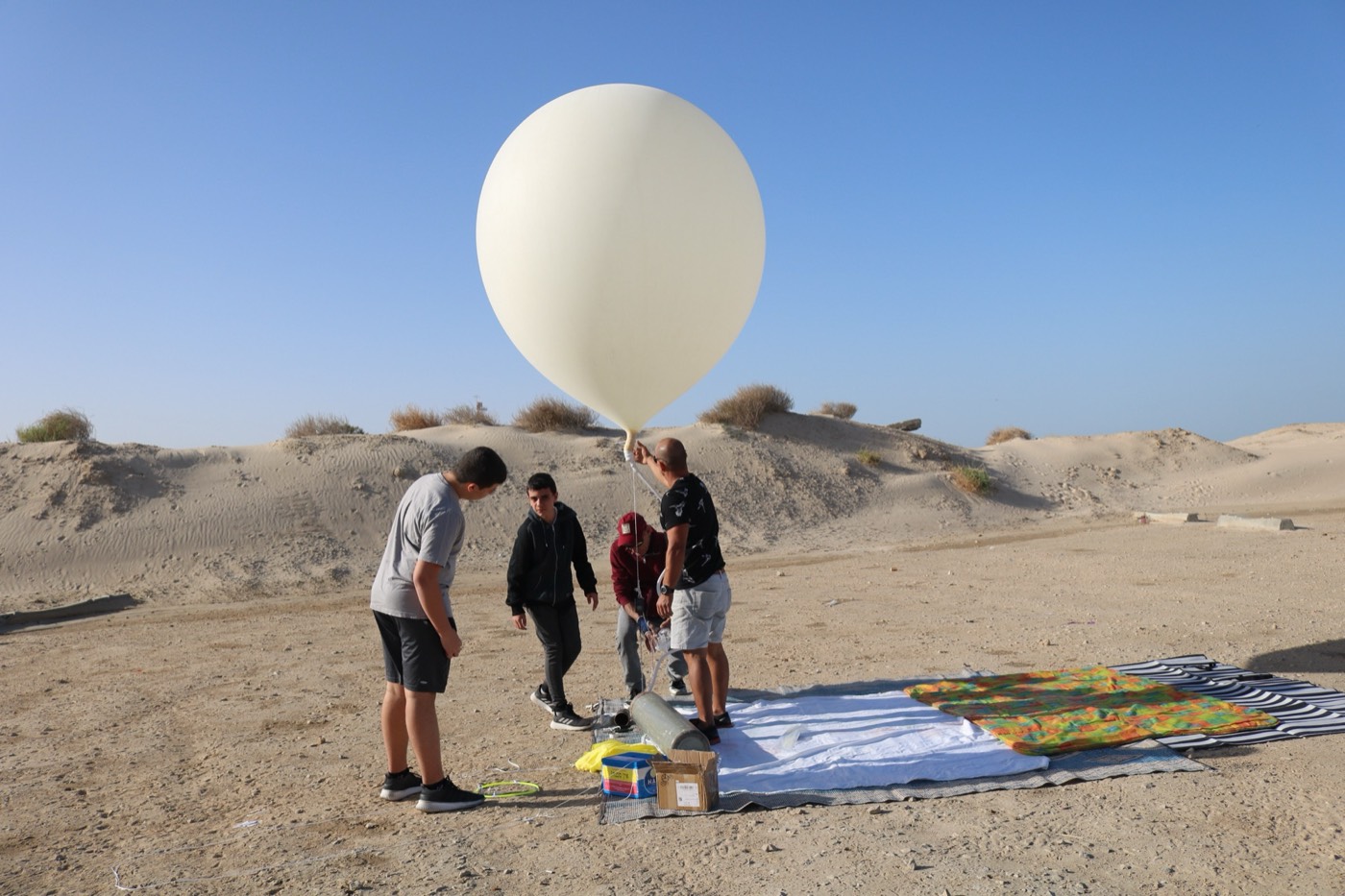 משפחה ממלאת בלון בחוף